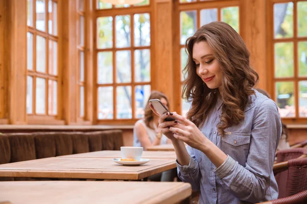 Femme utilisant un smartphone dans un café — Photo