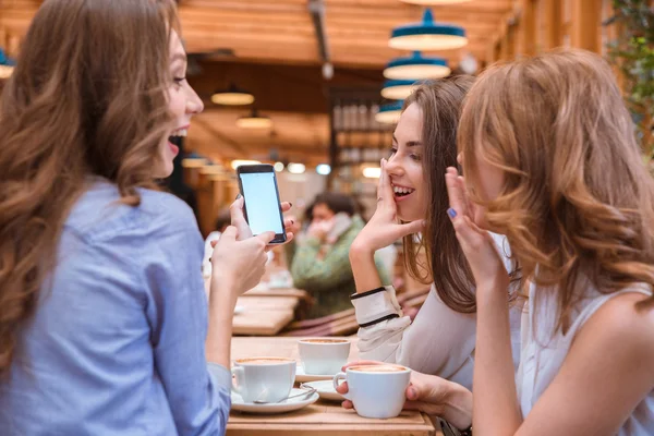 Bemutató valamit a smartphone képernyő barátnőivel nő — Stock Fotó
