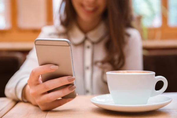 Female hands using smartphone in cafe — Stock Photo, Image