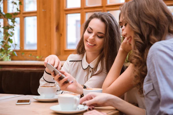 Женщины используют смартфон в кафе — стоковое фото