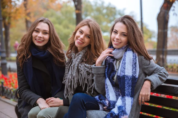 Három barátnő ül a padon a szabadban — Stock Fotó