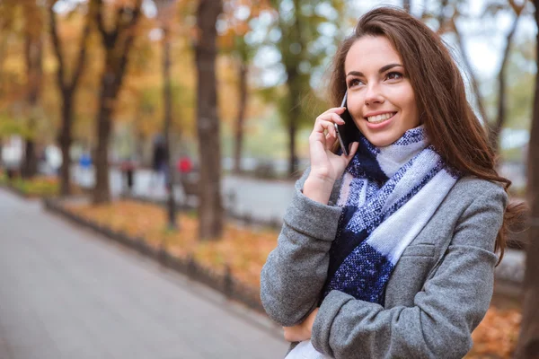 Dışarıda telefonla konuşan bir kadın. — Stok fotoğraf