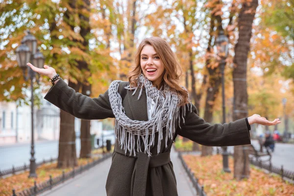 Woman standing with arms at sides in autumn park — Stock Photo, Image