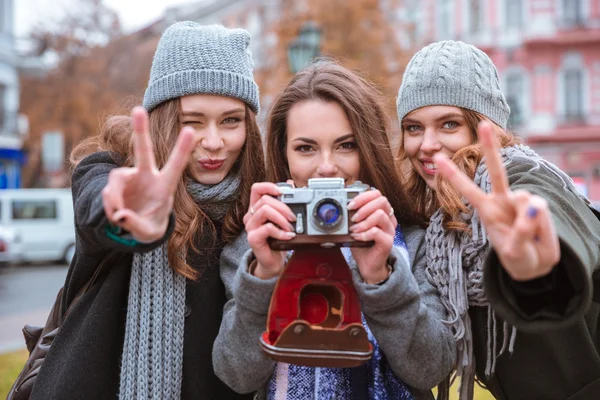 Três mulheres fazendo foto na câmera ao ar livre — Fotografia de Stock