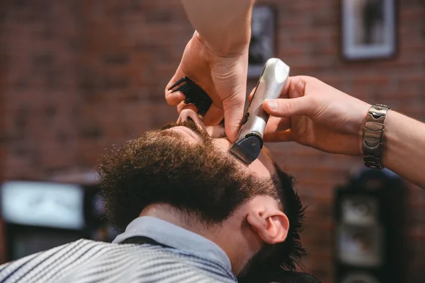 Jovem barbudo durante a barba na barbearia — Fotografia de Stock