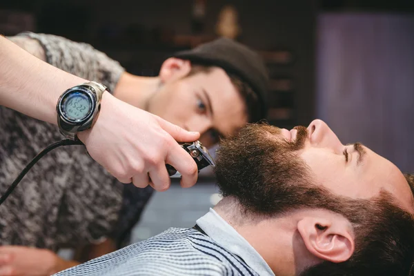 Bärtiger Mann lässt sich von modernem Friseur den Bart rasieren — Stockfoto