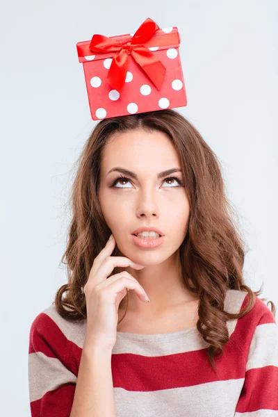 Mujer reflexiva mirando la caja de regalo en la cabeza —  Fotos de Stock