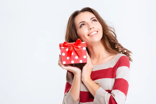 Happy thoughtful woman holding gift box and looking up — Stock Photo, Image