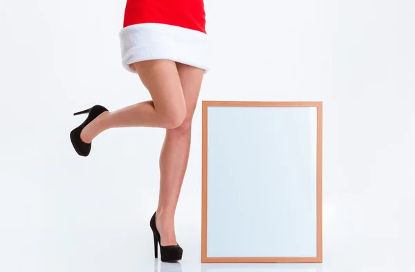 Patas femeninas en tela de Santa Claus y tablero en blanco —  Fotos de Stock