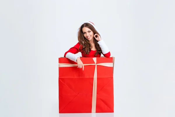 Очаровательная девушка в костюме Санта Клауса сидит в подарочной коробке — стоковое фото
