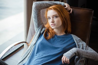 Kızıl saçlı kadın sallanan sandalye üzerinde rahatlatıcı