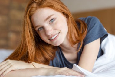 Yatakta yatan mutlu Kızıl saçlı kadın