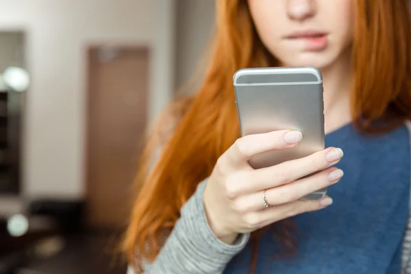 Redhead vrouw met behulp van smartphone — Stockfoto