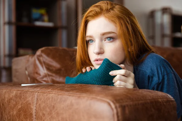 Bardzo zamyślony rudowłosy dziewczyna leżąc na kanapie i myślenia — Zdjęcie stockowe