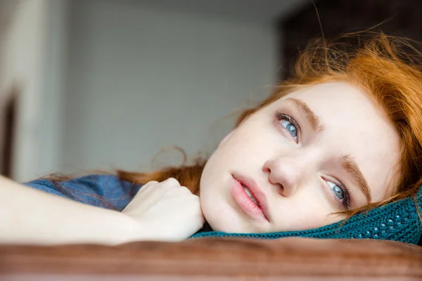 Mujer joven trastornada pensativa acostada en una almohada de punto —  Fotos de Stock