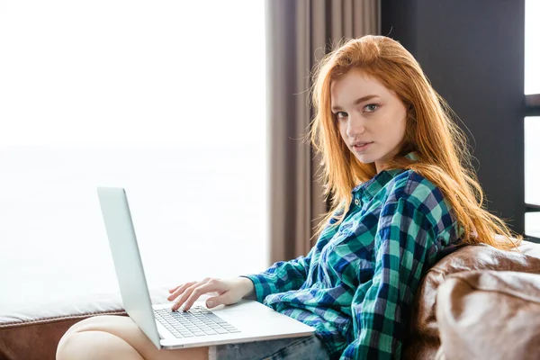 Atractiva mujer sensual con el pelo rojo usando el ordenador portátil —  Fotos de Stock