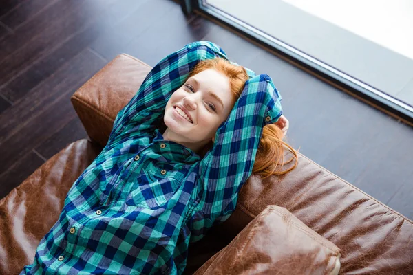 Dziewczyna pozytywny rudy spokojny odpoczynek na brązowe skórzane kanapy — Zdjęcie stockowe