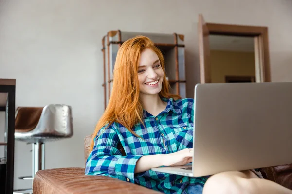 Chica alegre mirando en la pantalla de la computadora portátil y sonriendo —  Fotos de Stock