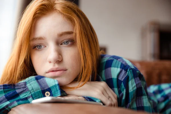 Triste joven pelirroja cansada pensando y escuchando música —  Fotos de Stock