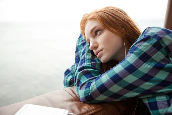 Pensive lady listening to music and looking away — Stock Photo, Image