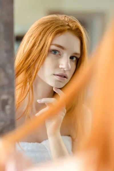 Redhead vrouw haar reflectie in de spiegel kijken — Stockfoto