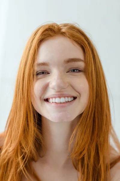 Hymyilevä punapää nainen katselee kameraa — kuvapankkivalokuva
