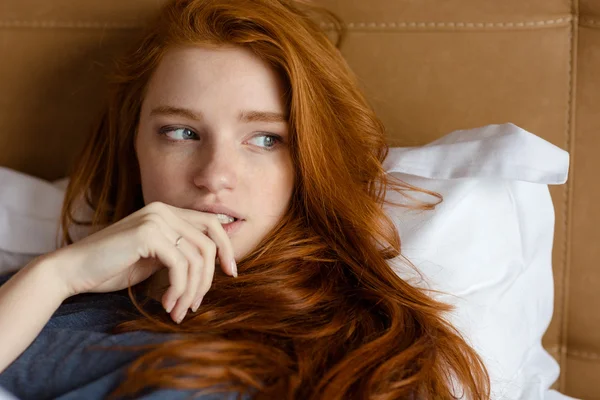 Vacker eftertänksam kvinna ligger på sängen — Stockfoto
