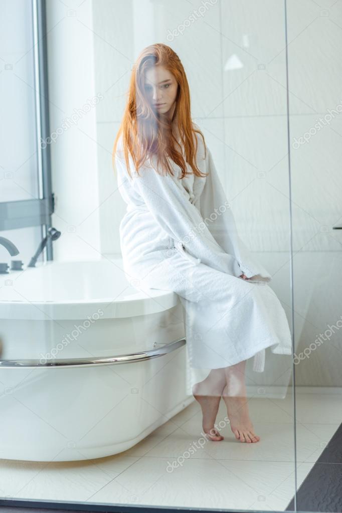 Femme rousse en peignoir assis dans la salle de bain — Photo de