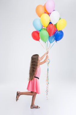 Yan görünüm portre renkli balonlar ile küçük kız