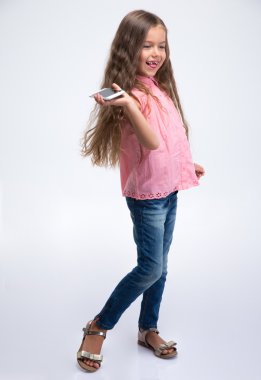 Küçük bir kız holding Smartphone tam uzunlukta portirat 