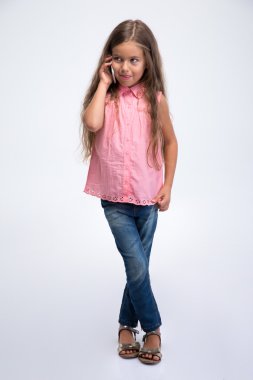 Küçük kız telefonda konuşuyor. 