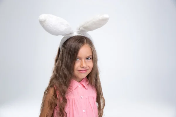Маленькая девочка с кроличьими ушами смотрит в камеру — стоковое фото