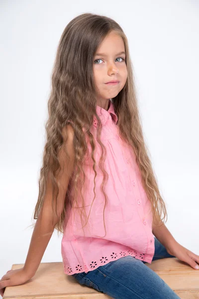 나무 상자에 앉아 아름 다운 어린 소녀의 초상화 — 스톡 사진