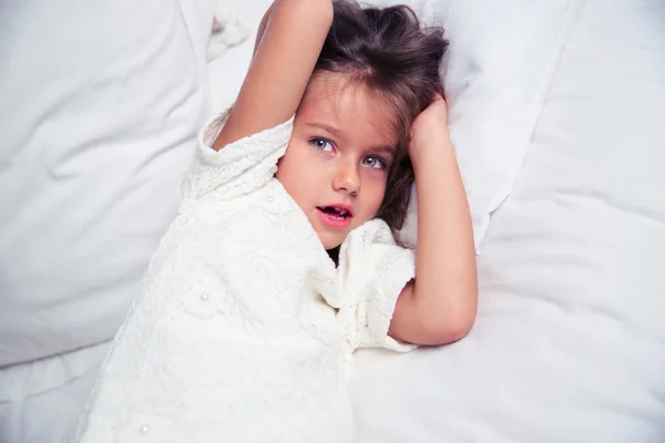 Портрет маленькой девочки, лежащей в постели — стоковое фото