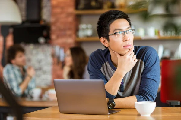 カフェでノート パソコンに座ってと離れているアジア人男性 — ストック写真