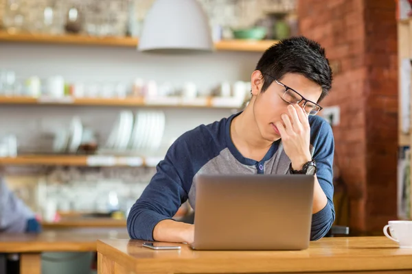 Cansado agotado asiático macho trabajando con laptop — Foto de Stock