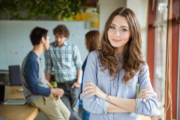 Femme debout près de la fenêtre avec ses collègues sur fond — Photo