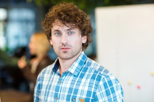 Male student with curly hair looking at camera — Stock Photo, Image