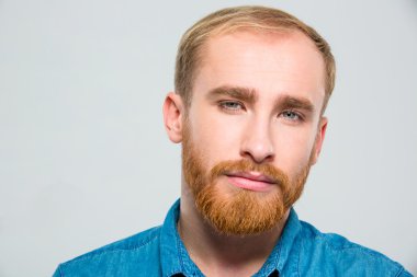 Serious thoughtful bearded young man looking camera