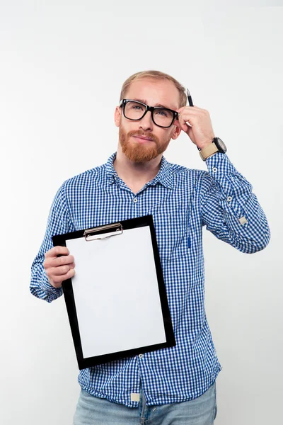 Pensivo casual homem mostrando prancheta em branco — Fotografia de Stock