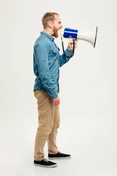 Retrato de vista lateral de um homem casual gritando em megafone — Fotografia de Stock