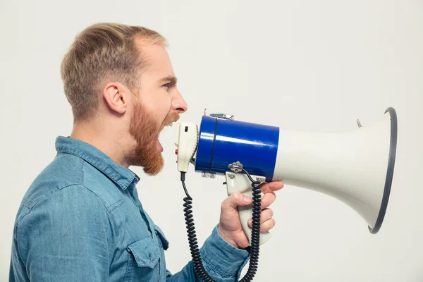 Casual man yelling into megaphone — Stock Photo, Image