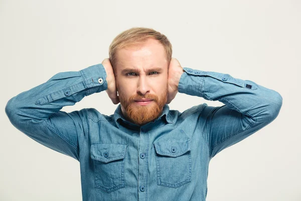 Boos, gefrustreerd, bebaarde man gesloten oren door handen — Stockfoto