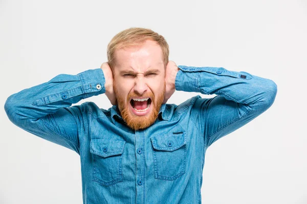 Pazzo uomo isterico chiuso le orecchie a mani e urlando — Foto Stock