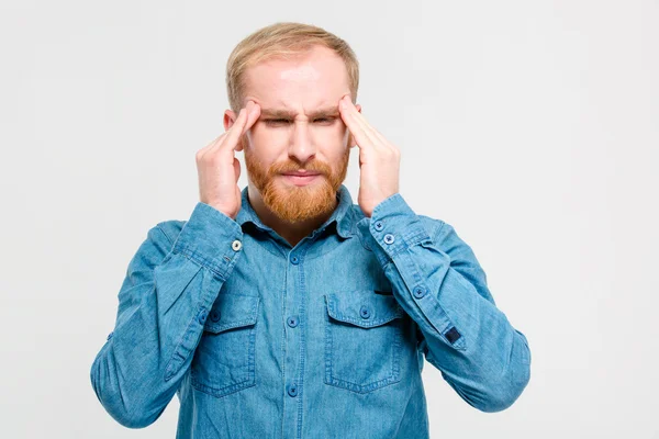 Jonge depressief bebaarde man raken zijn tempels en met hoofdpijn — Stockfoto