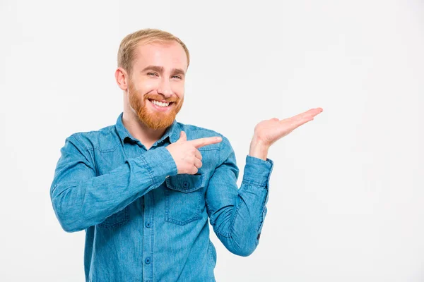 Glücklich lächelnder junger Mann mit Bart hält Kopierplatz auf der Handfläche — Stockfoto
