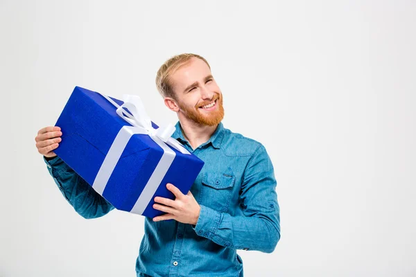 Happy cheerful man with beard holding a present — Zdjęcie stockowe