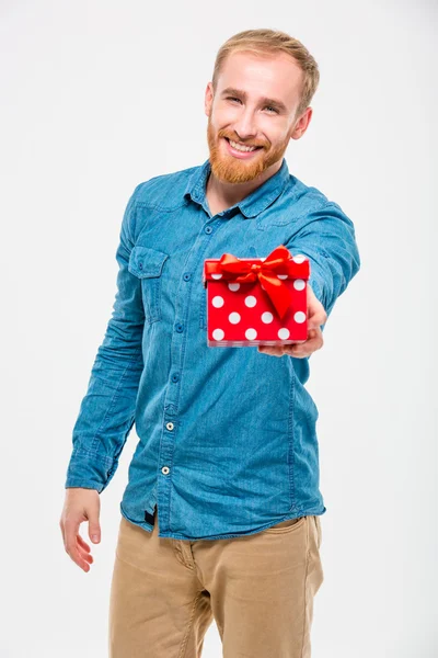 Attractive positive male with beard giving present to you — Zdjęcie stockowe