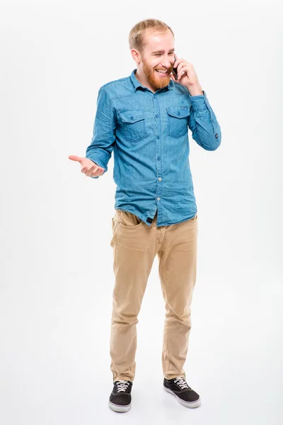 Cheerful happy bearded man standing and talking on cellphone — Stok fotoğraf