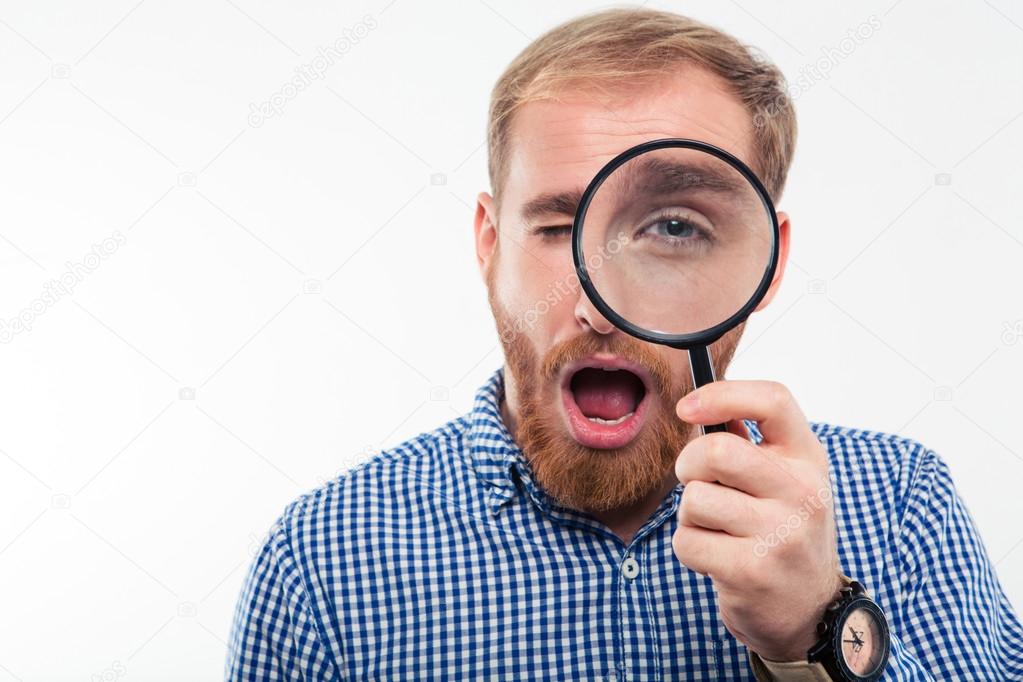 Man looking through magnifying glass at camera